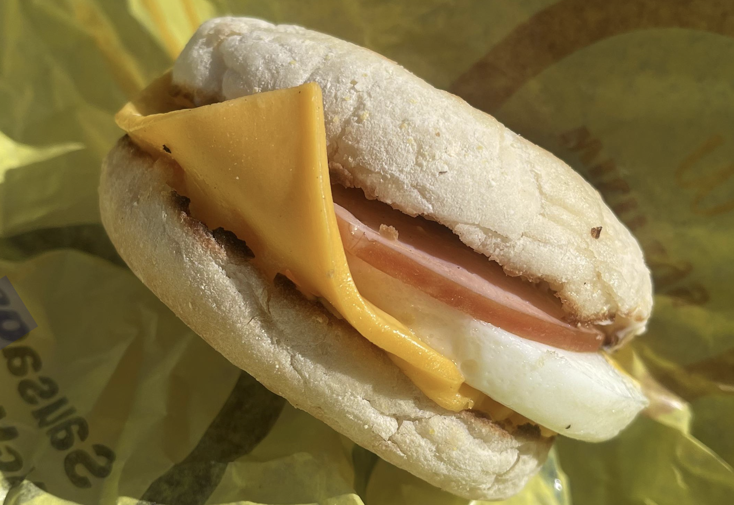 An egg, Canadian bacon, and cheese breakfast sandwich on an English muffin.