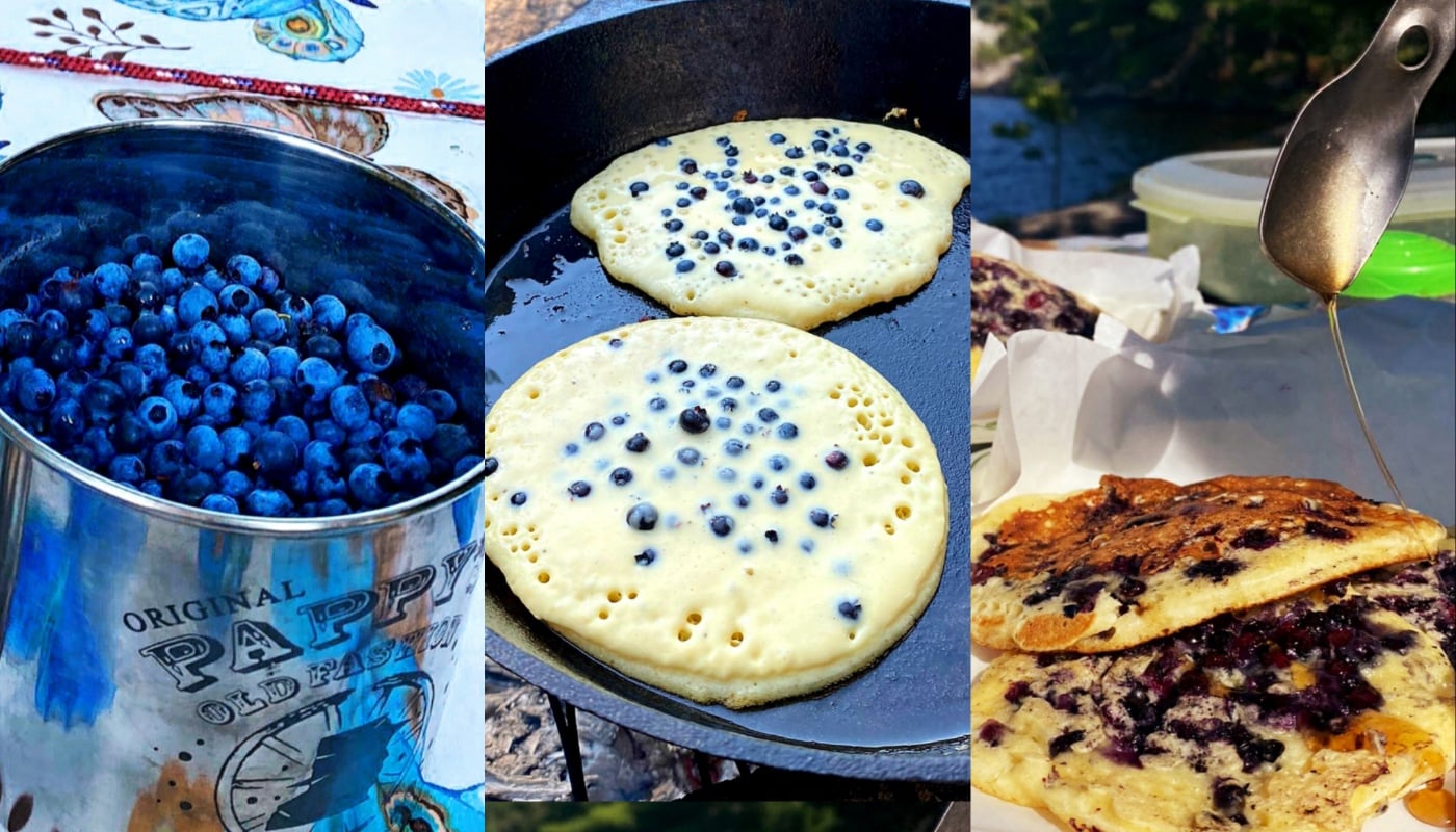 A bucket of freshly picked blueberries, two blueberry pancakes cooking in a cast-iron skillet, and syrup being poured over stacked blueberry pancakes.