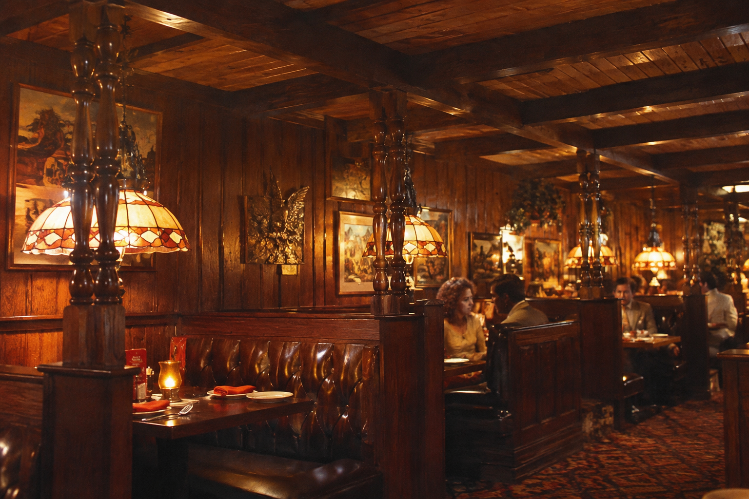Dimly lit vintage restaurant with wood-paneled walls, stained glass hanging lamps, and brown leather booths. Diners are seated at tables, creating a cozy, classic atmosphere. Paintings and decor add to the warm ambiance.