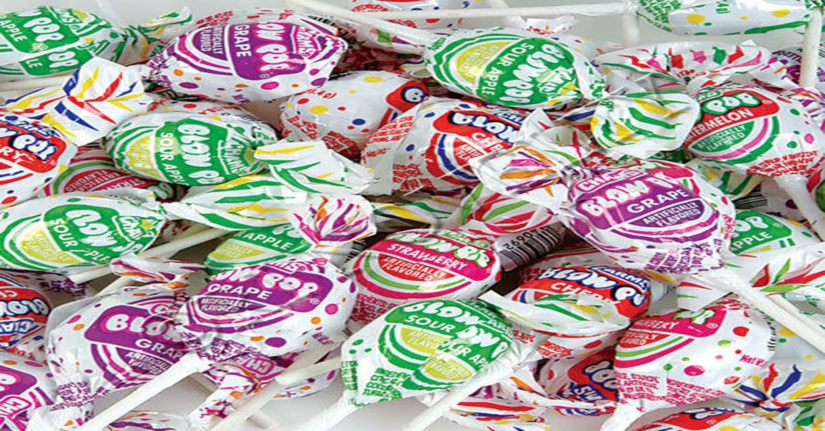 A pile of various Blow Pop lollipops in colorful wrappers.