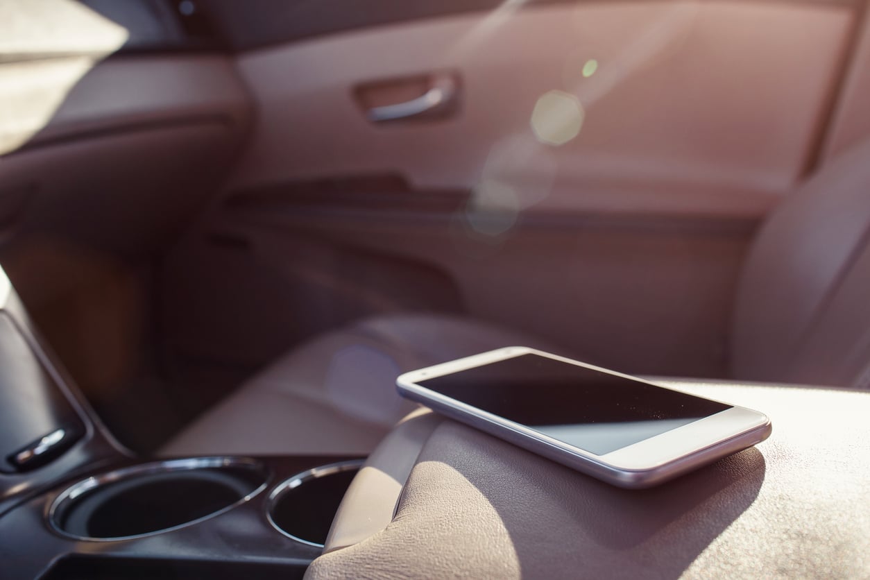 A smartphone lying on the center console of a car.