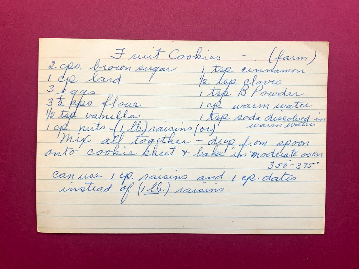 Handwritten recipe card for “Fruit Cookies (farm)” listing ingredients including brown sugar, lard, eggs, flour, raisins, and spices, along with baking instructions.