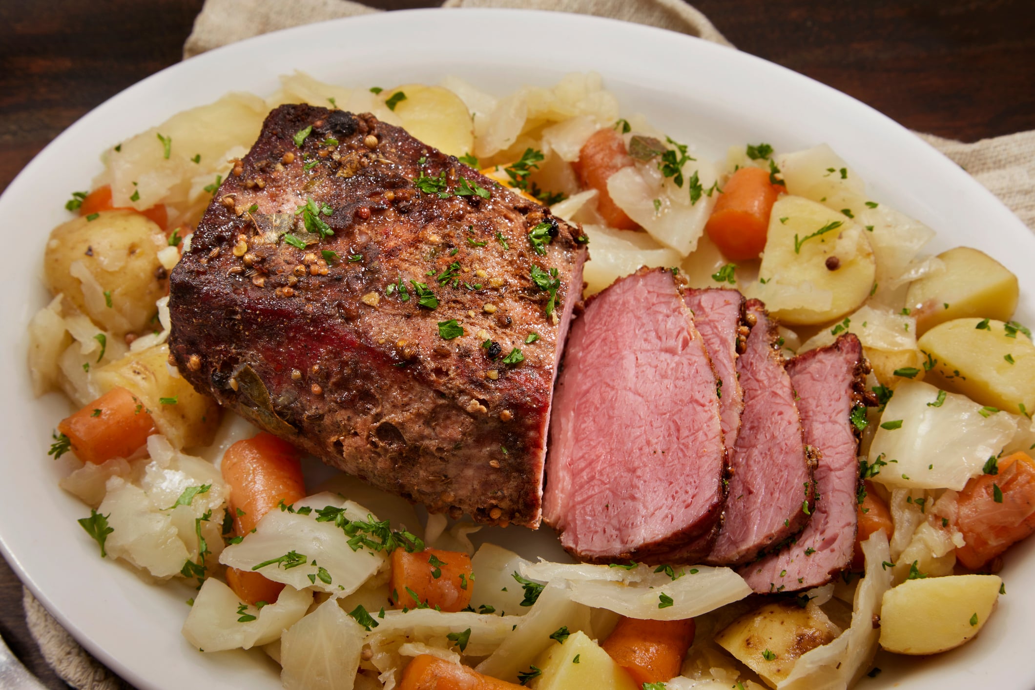 A platter of corned beef served with boiled potatoes, carrots, and cabbage.
