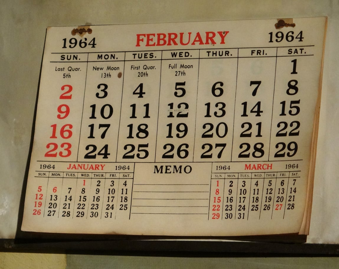 A 1964 wall calendar showing February as the main month, with January and March calendars below it.