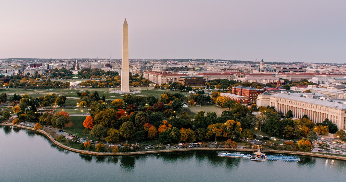 Aerial view of the Washington Monument surrounded by parkland and autumn foliage, perfect for trips that feel luxurious, with the Tidal Basin in the foreground and the D.C. skyline in the distance.