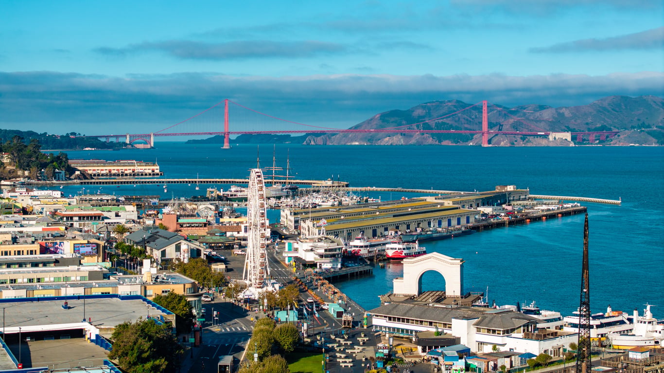 Aerial view of San Francisco’s Fisherman’s Wharf and Pier 39 with the Golden Gate Bridge in the distance.