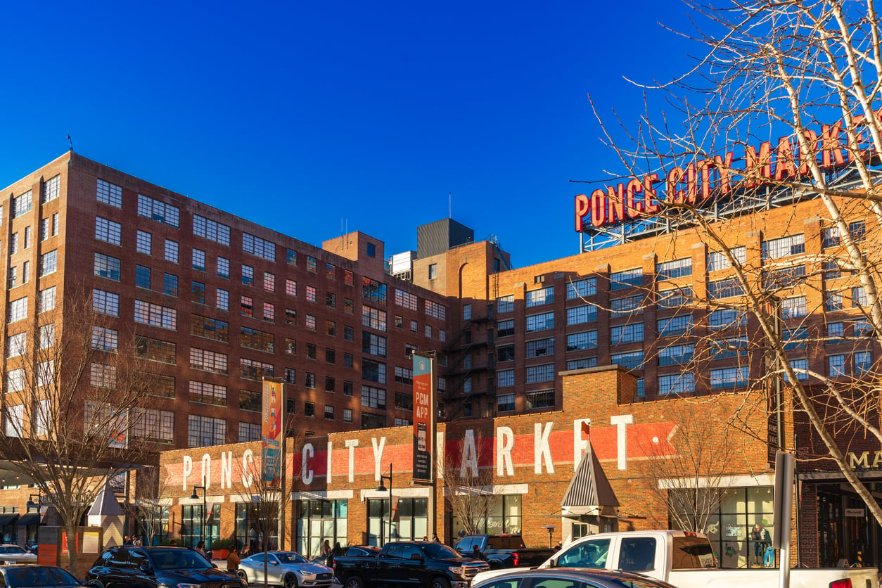 The Ponce City Market building, a large brick structure with a prominent rooftop sign and signage on the exterior wall.