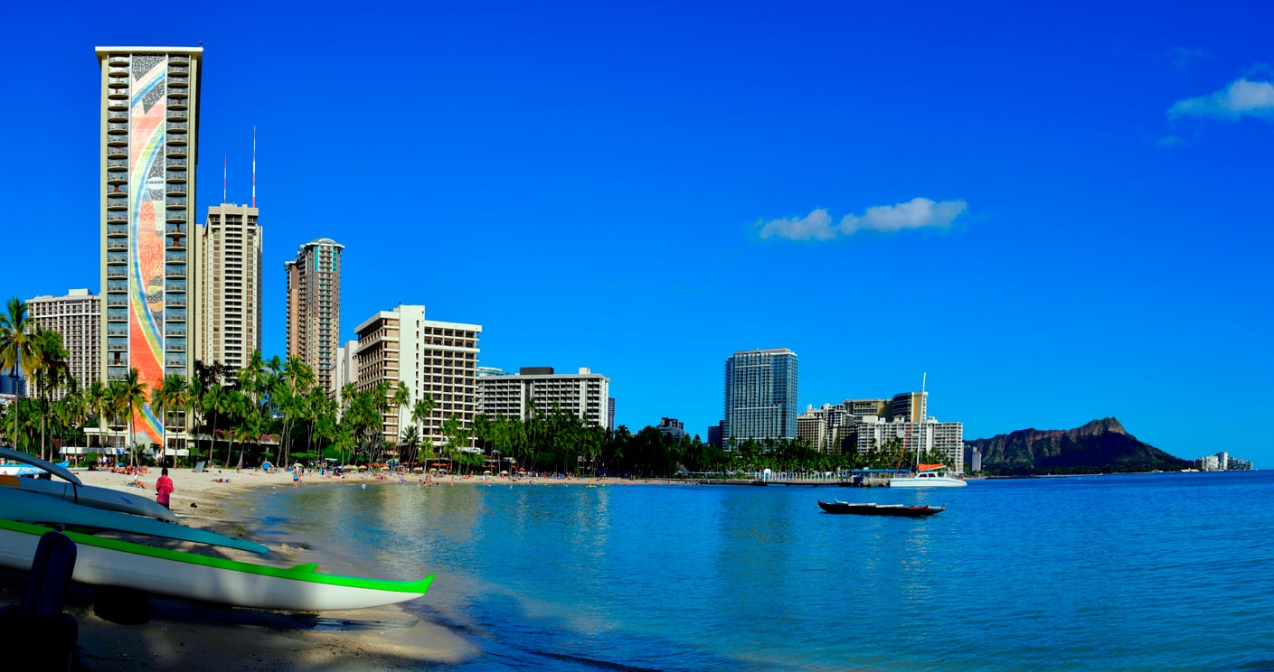 Waikiki Beach with high-rise hotels along the shoreline and Diamond Head crater in the distance.