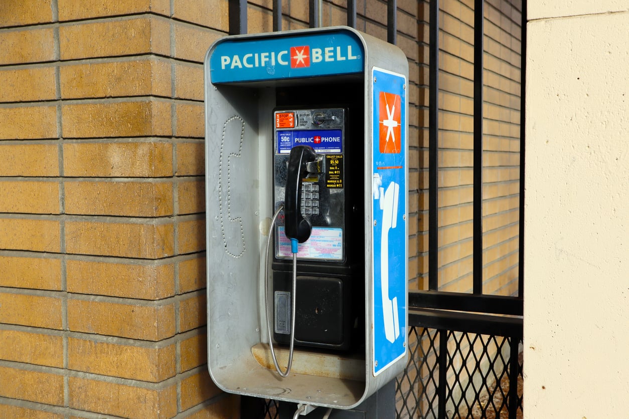 A Pacific Bell public payphone mounted to a brick wall.