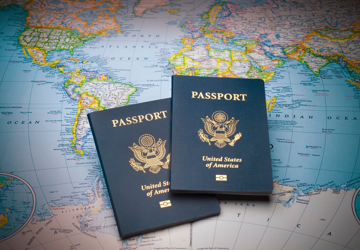 Two United States passports resting on top of a world map.