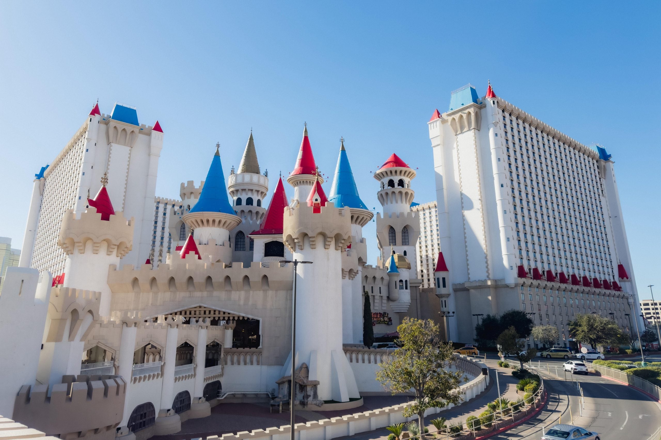 The Excalibur Hotel and Casino in Las Vegas featuring white castle-style towers with red and blue conical roofs.