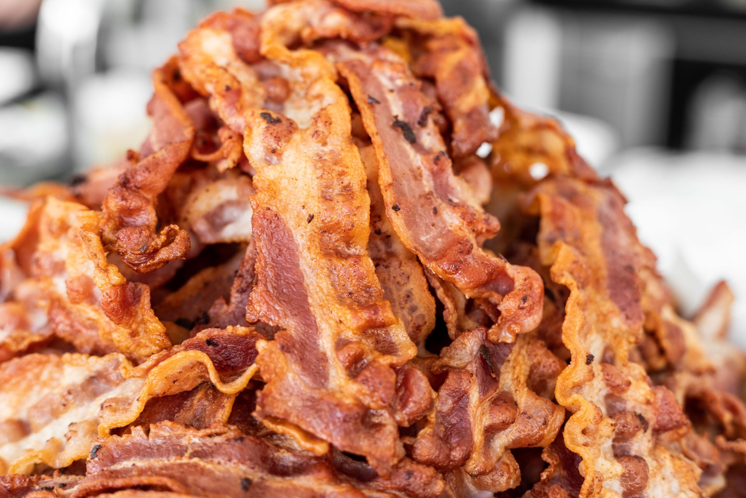 A large pile of crispy, cooked bacon strips.