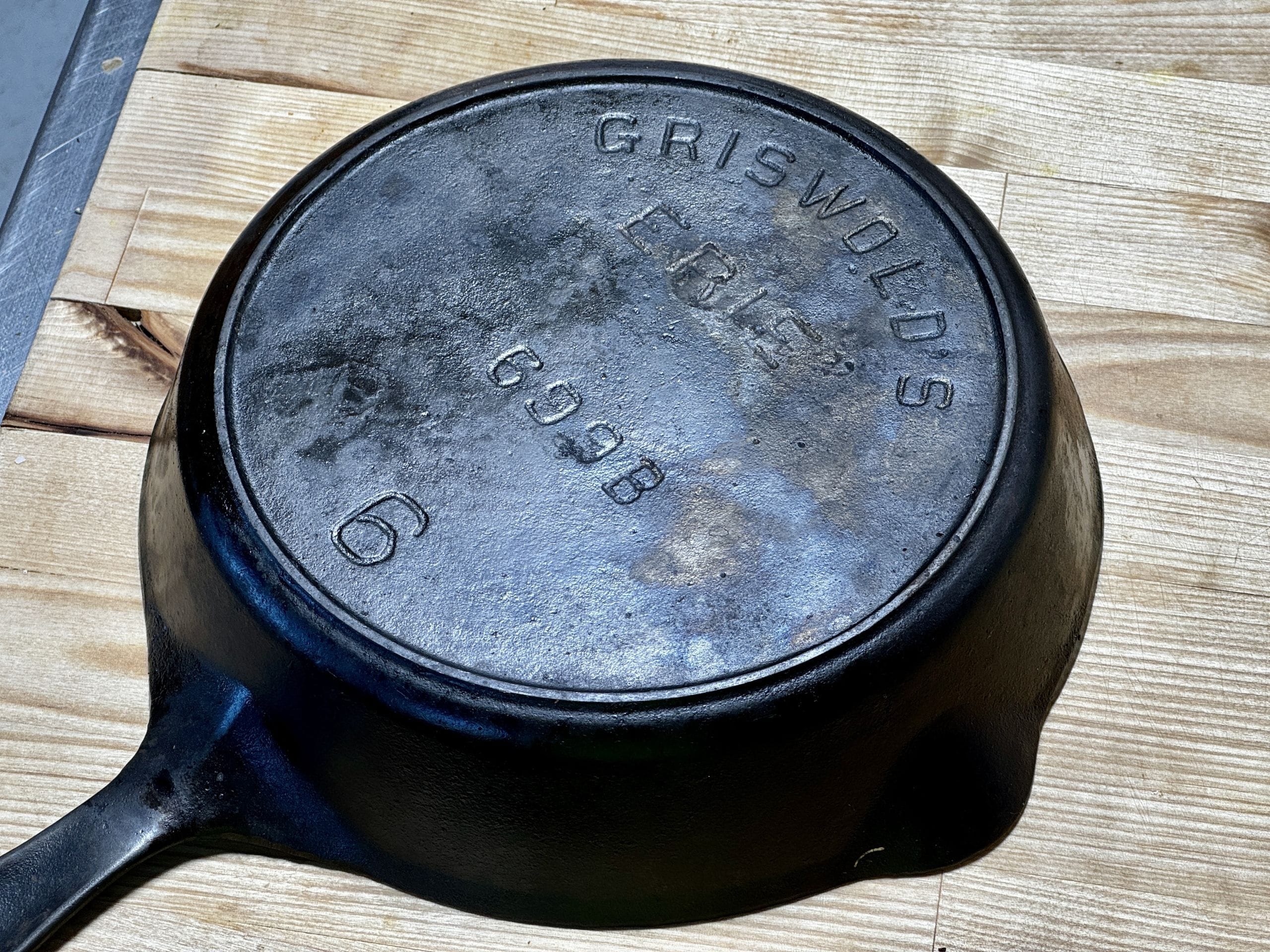 The underside of a vintage cast iron skillet embossed with “Griswold’s Erie” and the number 6.